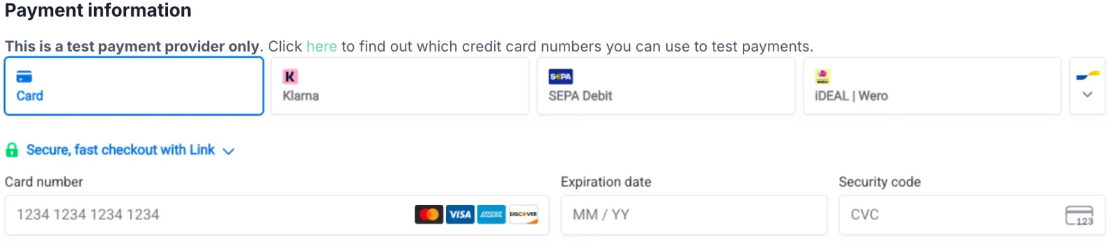 Abschnitt „Zahlungsinformationen“ einer Checkout-Seite im Test-Status. Darüber der englische Hinweis „This is a test payment provider only. Click here to find out which credit card numbers you can use to test payments.“ Darunter die Auswahlkacheln Karte, Klarna, SEPA-Lastschrift und iDEAL | Wero sowie die Felder Kartennummer, Ablaufdatum und Sicherheitscode.